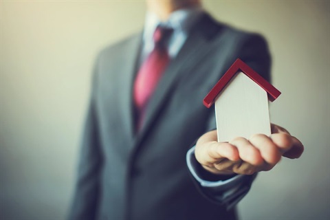 Property manager holding a model of a home